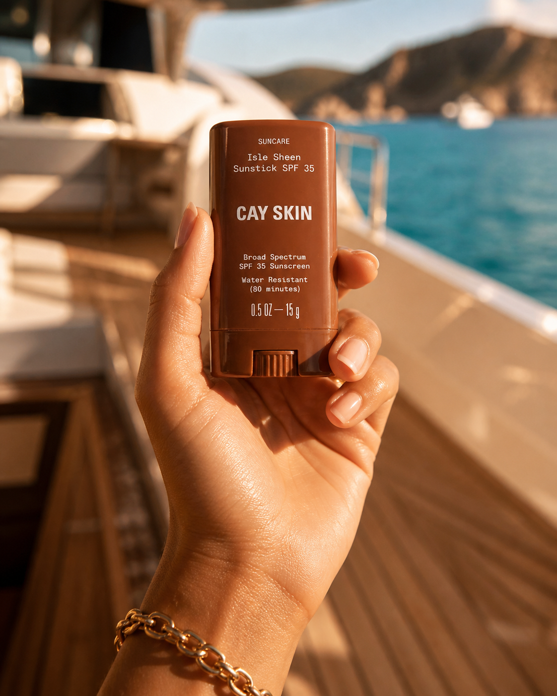 Cay Skin Isle Invisible Sunstick held in melanin-rich hand on a yacht at golden hour